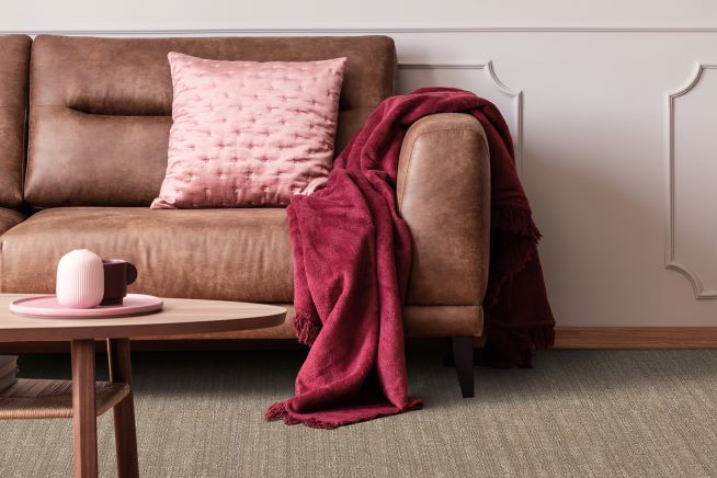 brown textured carpet in a modern stylish living room with a brown leather couch and pink accents